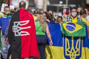 Manifestante carrega bandeira de movimento neonazista da Ucrânia (preta e vermelha) em ato pró-Bolsonaro - Marlene Bergamo