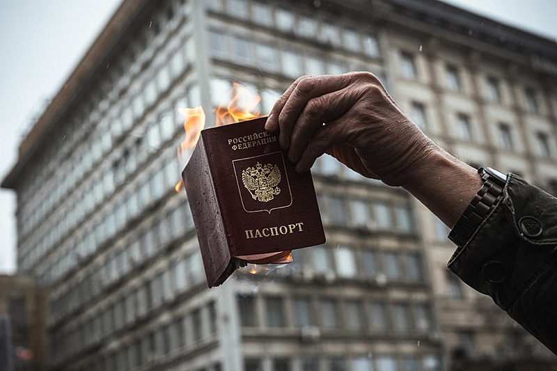 Um protestante queima seu passaporte russo [Imagem: Reprodução/Andrej Isakovic - AFP]